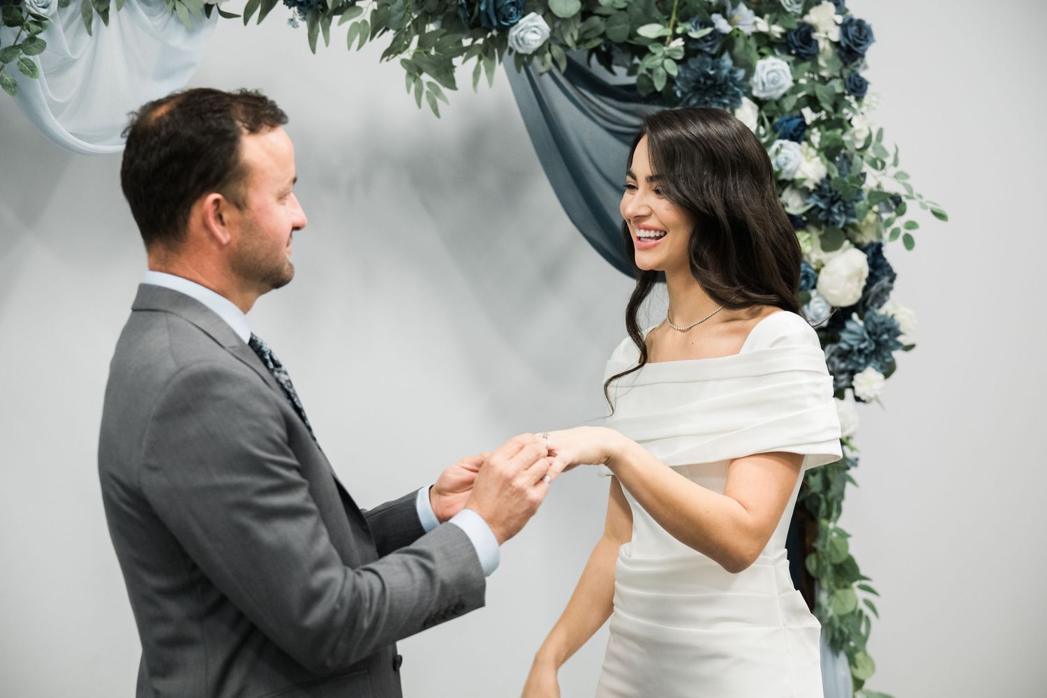 Two people share a romantic moment under decorative floral garlands.