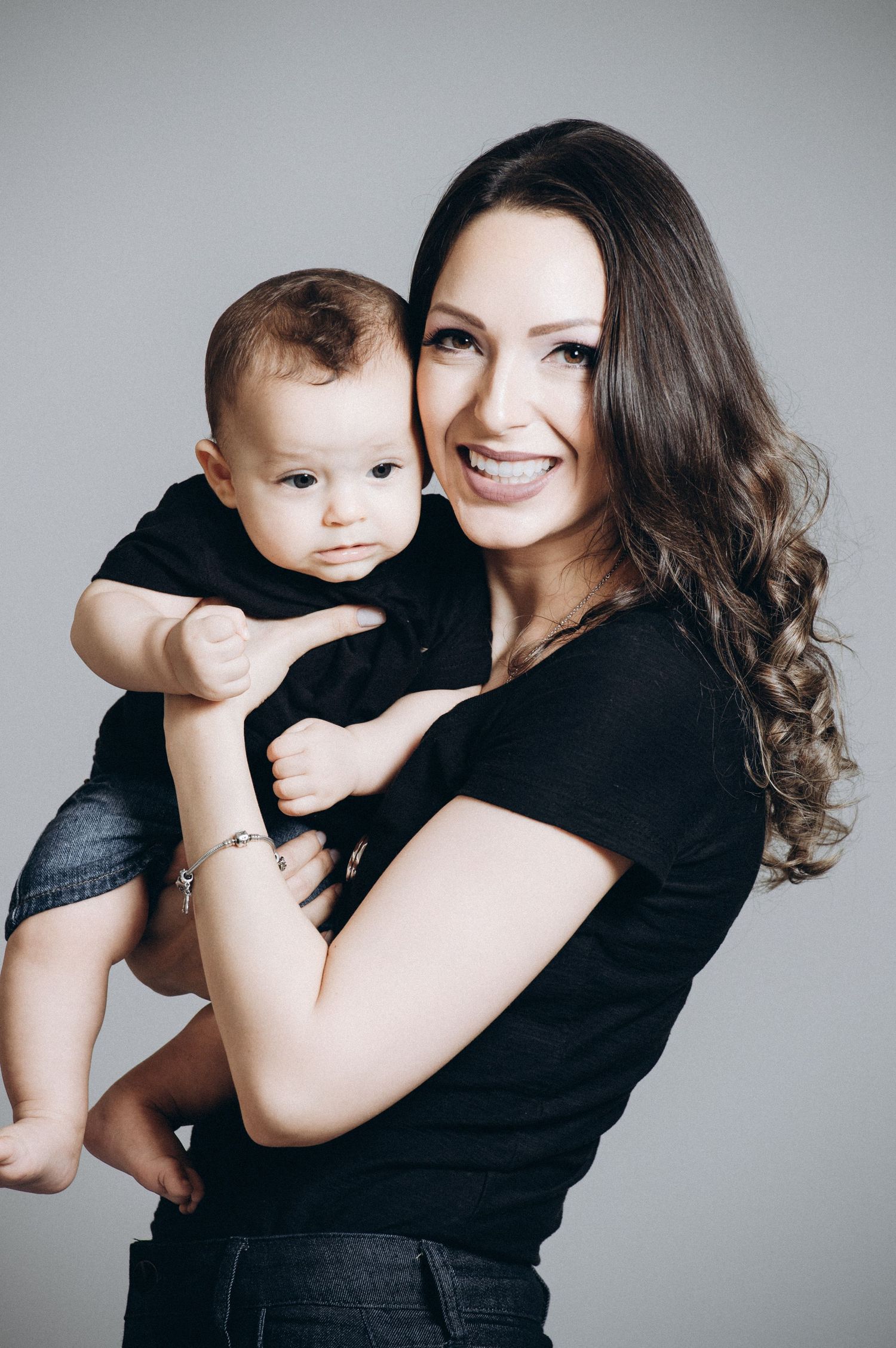 Modern family portrait series with everyone dressed in black against light gray background.