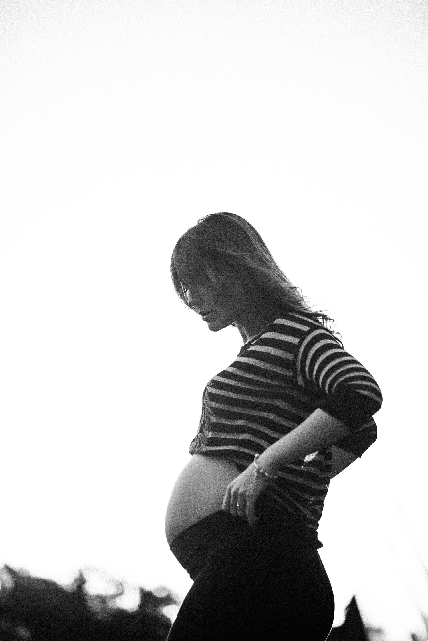 Silhouette maternity photos showing pregnant woman's profile against white background.