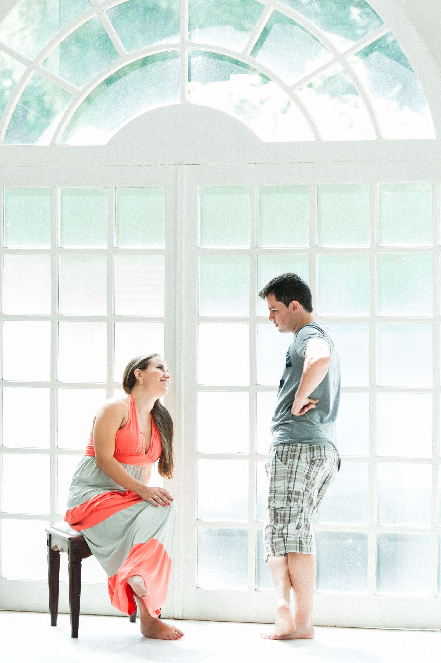 Romantic couple interaction sequence in front of arched windows.