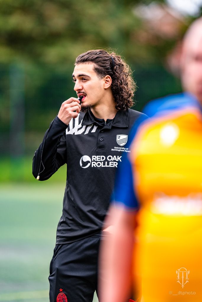 Young referee standing on a football field.