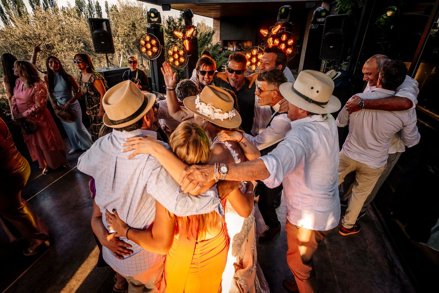People dancing in a dimly lit venue wearing cowboy hats and western attire at a country western dance event.