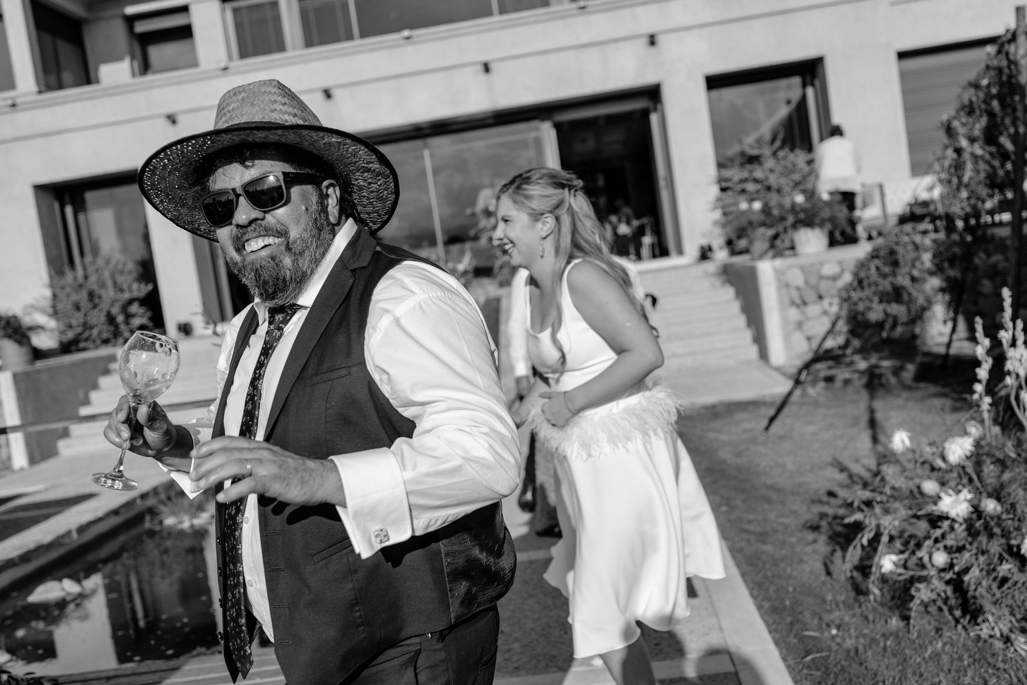 Black and white photo series showing a wedding party walking and celebrating in a city street.