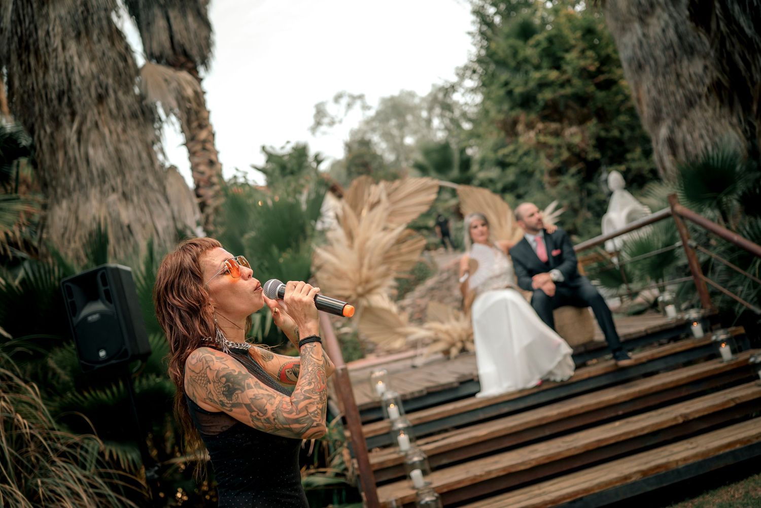 Person drinking from a bottle while sitting on church pews during a social gathering.