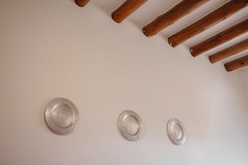 Rustic wooden ceiling beams against white walls in a modern interior space.
