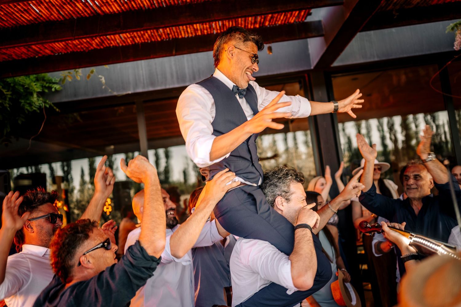 Wedding guests dance and celebrate together on a lively dance floor during an evening reception.