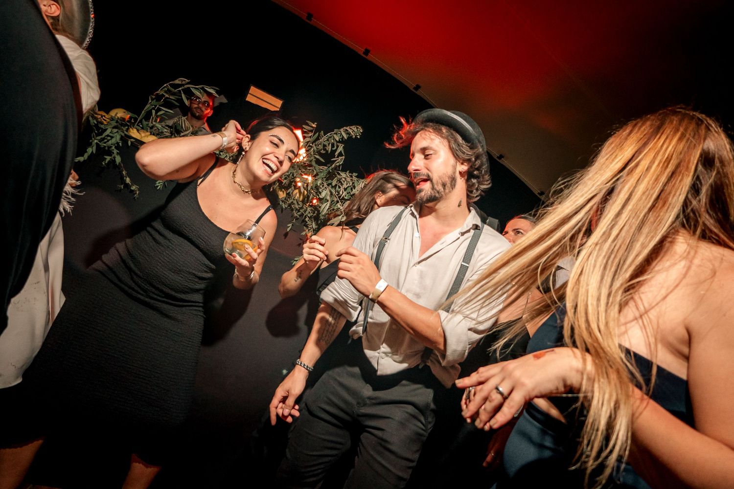People dancing and celebrating at a lively party with dynamic movement and energetic atmosphere.