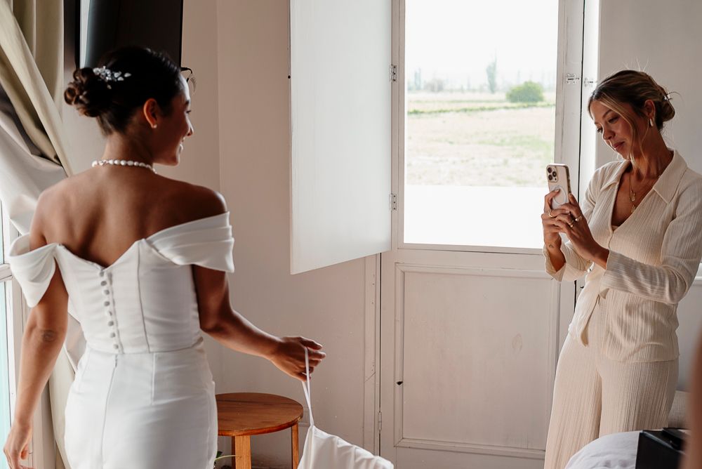 A bride in an elegant white off-shoulder wedding dress gets ready in a bright sunlit room. wedding in mendoza