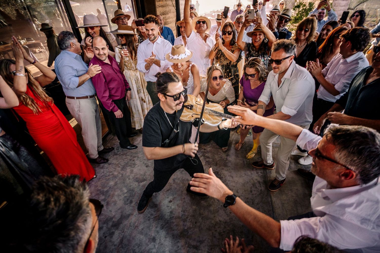Wedding guests dance and celebrate together during a lively reception party on a dance floor.