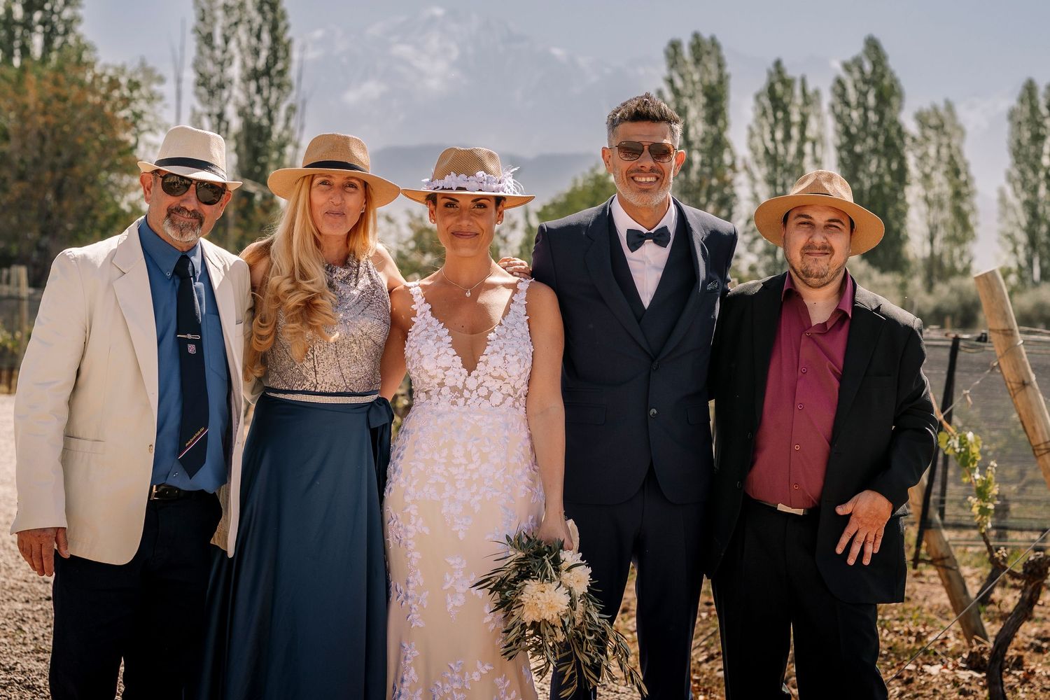 Group photo taken outdoors with tall poplar trees in the background on a sunny autumn day.