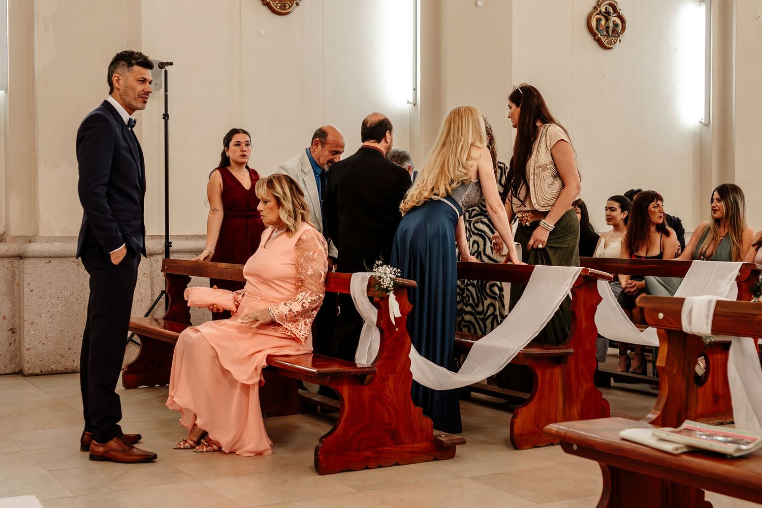 Wedding guests kneel in prayer during an intimate church ceremony service.
