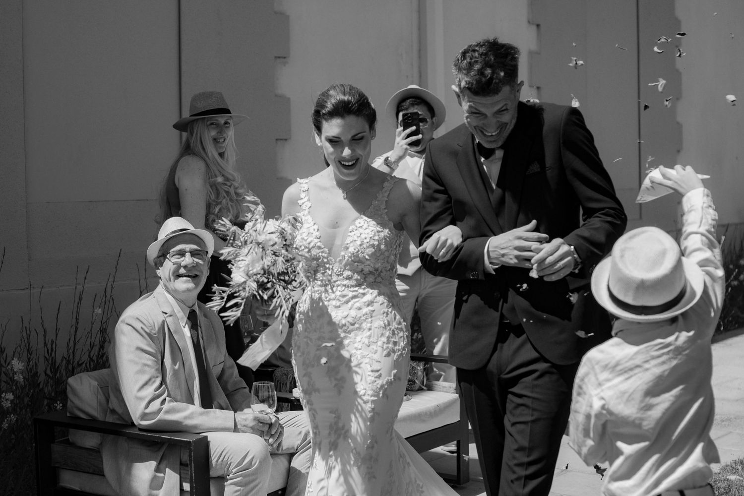 A sequence of black and white photos showing wedding guests celebrating and dancing at a reception party.