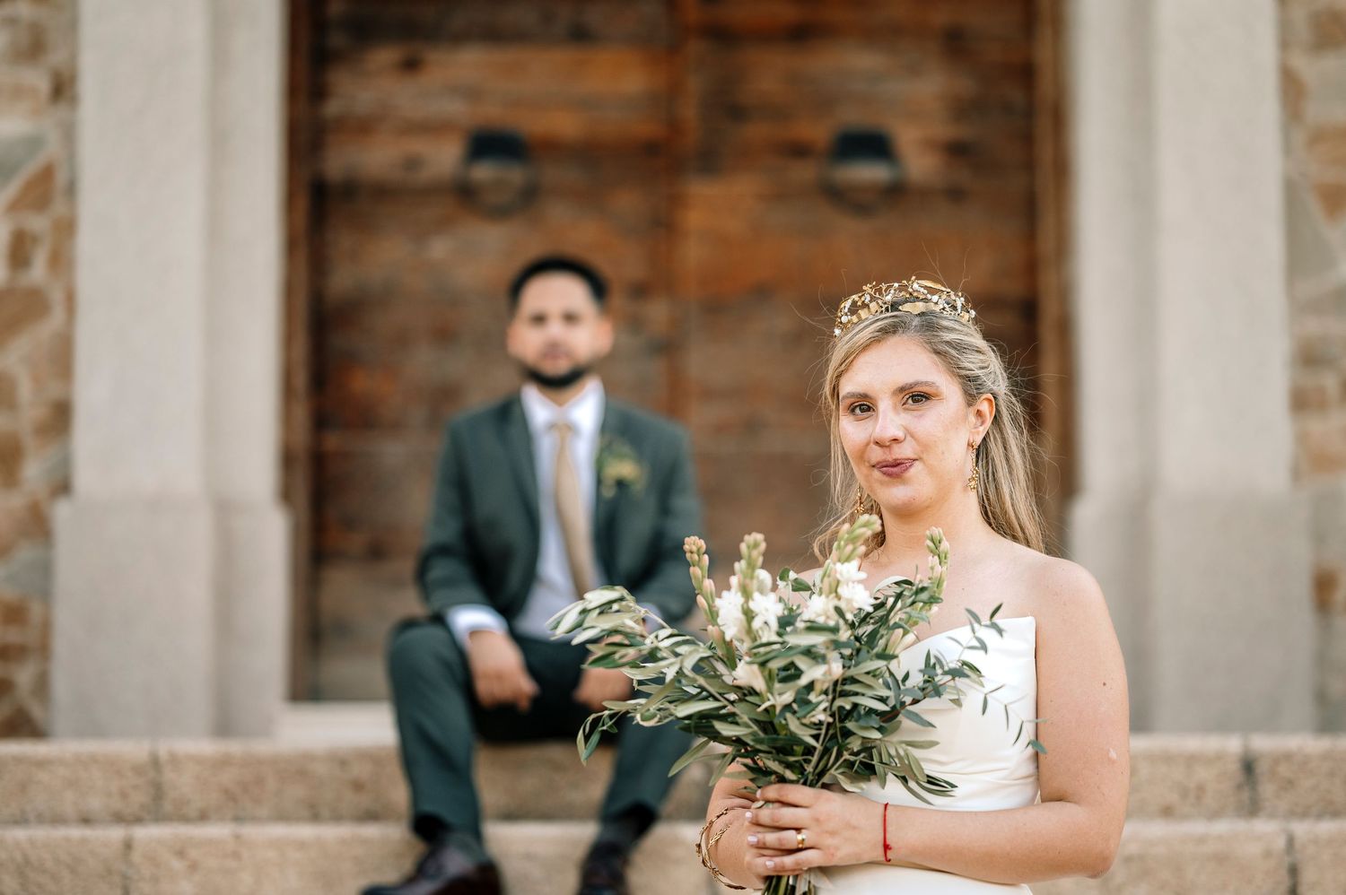 A wedding party poses on stone steps with elegant greenery bouquets and formal attire. fotografos de boda en mendoza