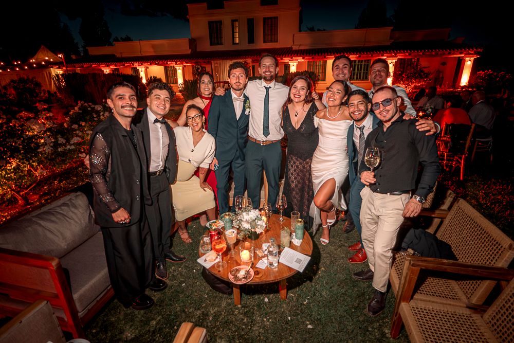 Group of people enjoying an evening gathering at a dimly lit venue with red ambient lighting.