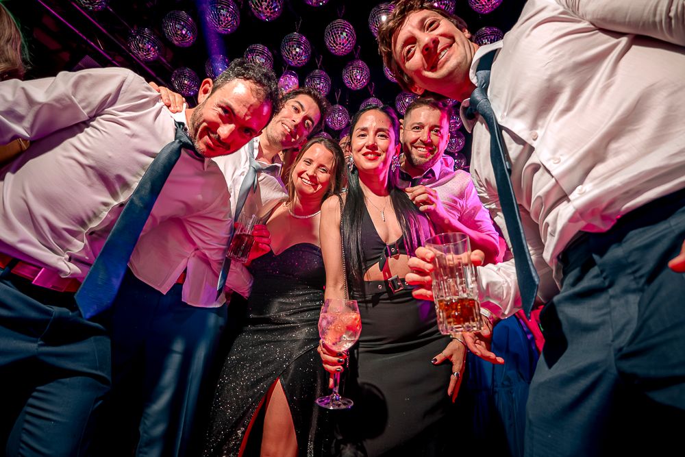 A lively group of party guests dance and celebrate together on a crowded dance floor at a festive event. fotografos de boda en mendoza