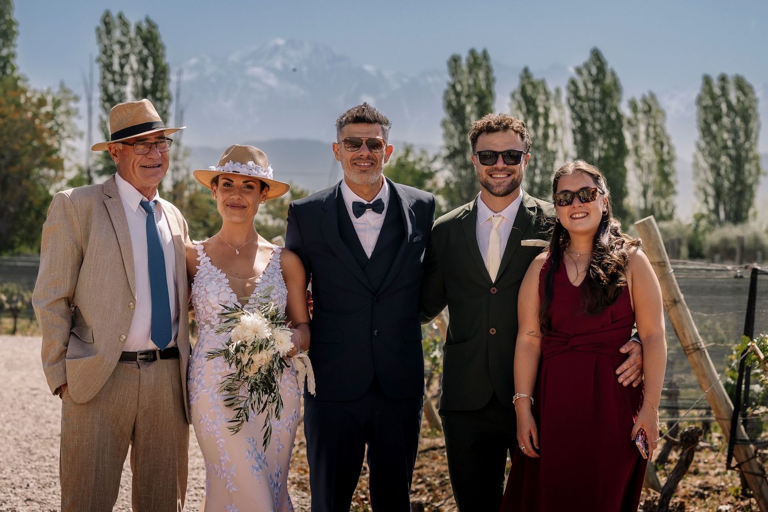 Group gathered at a rustic outdoor venue with tall trees and natural landscape in the background.