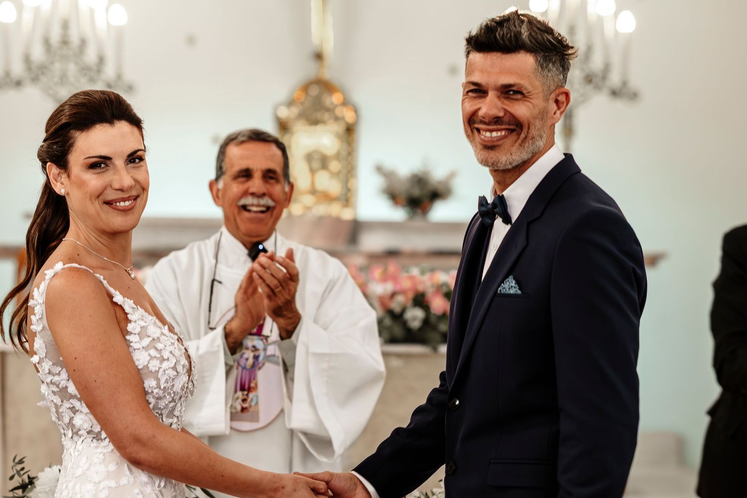 Wedding party celebrates with joyful laughter and dancing during a reception in an elegant ballroom.