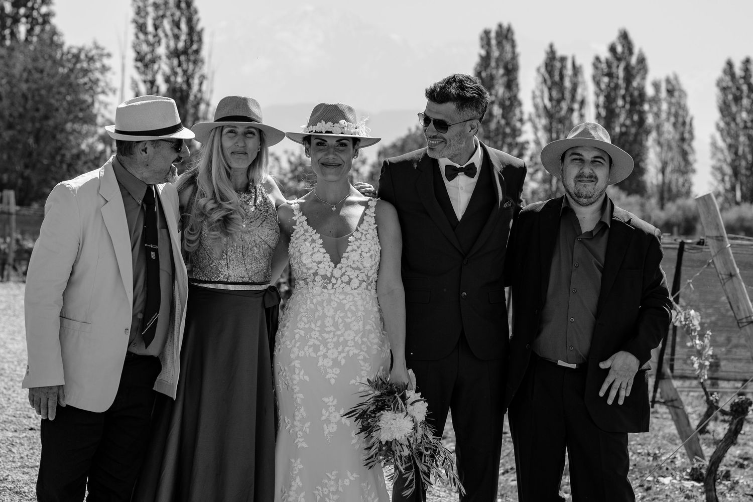 A collection of black and white wedding photos showing couples and groups celebrating outdoors.