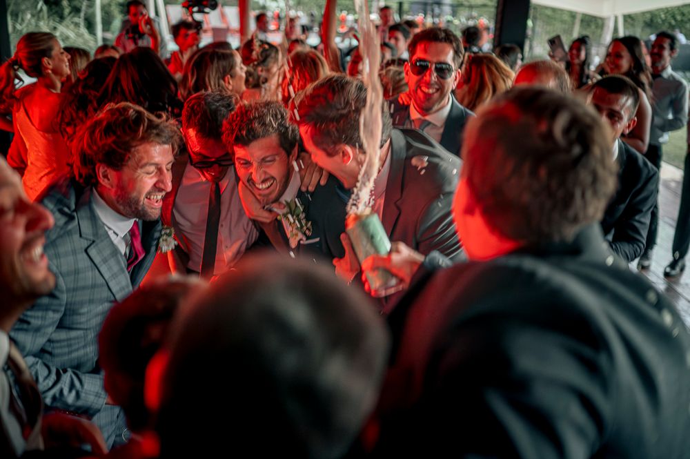 A crowded dance floor filled with people dancing under red lighting at a nightclub party. wedding in mendoza