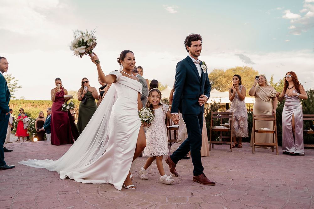 A joyful wedding celebration with a couple walking down the aisle while guests watch at an outdoor desert ceremony. wedding in mendoza