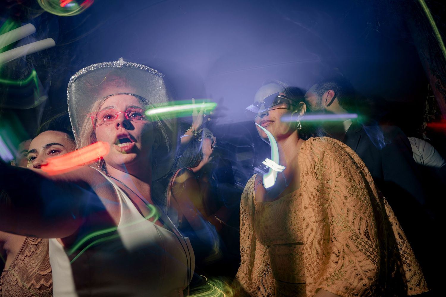 Energetic performers dance and move on stage with colorful lights and atmospheric smoke effects during a live show.