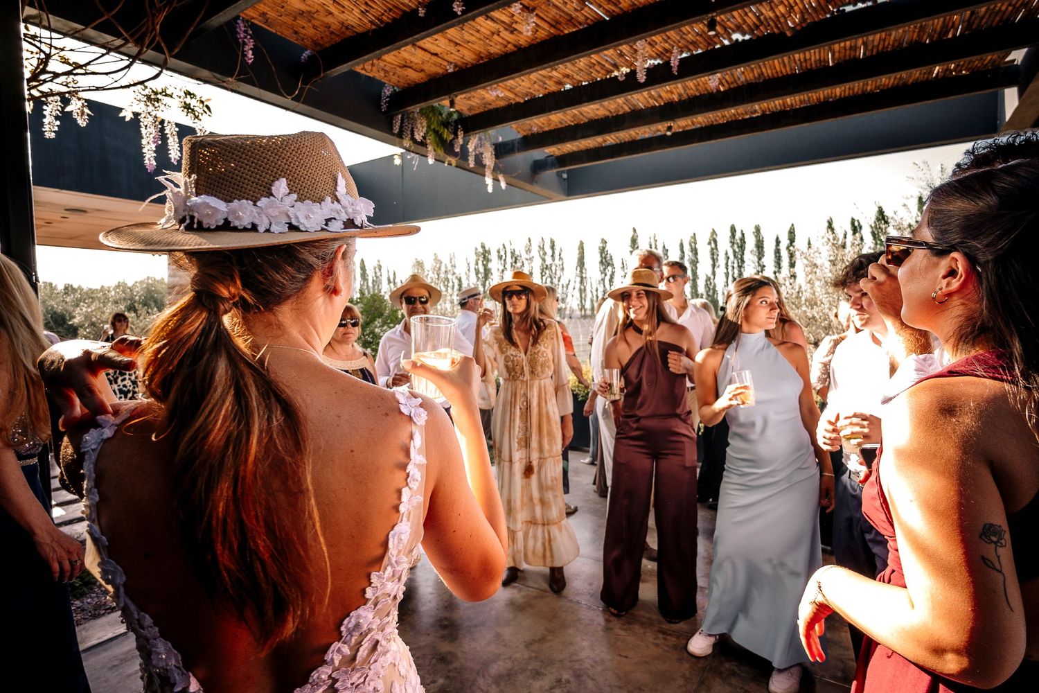 Wedding guests dance and celebrate together on a rustic wooden dance floor at an indoor reception venue.