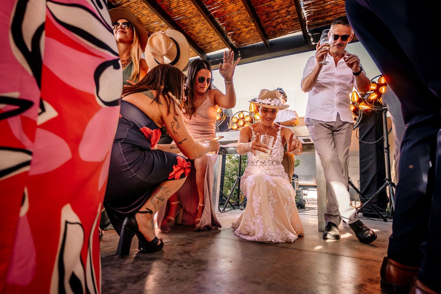 Wedding guests dance and celebrate on a dimly lit dance floor during an evening reception celebration.