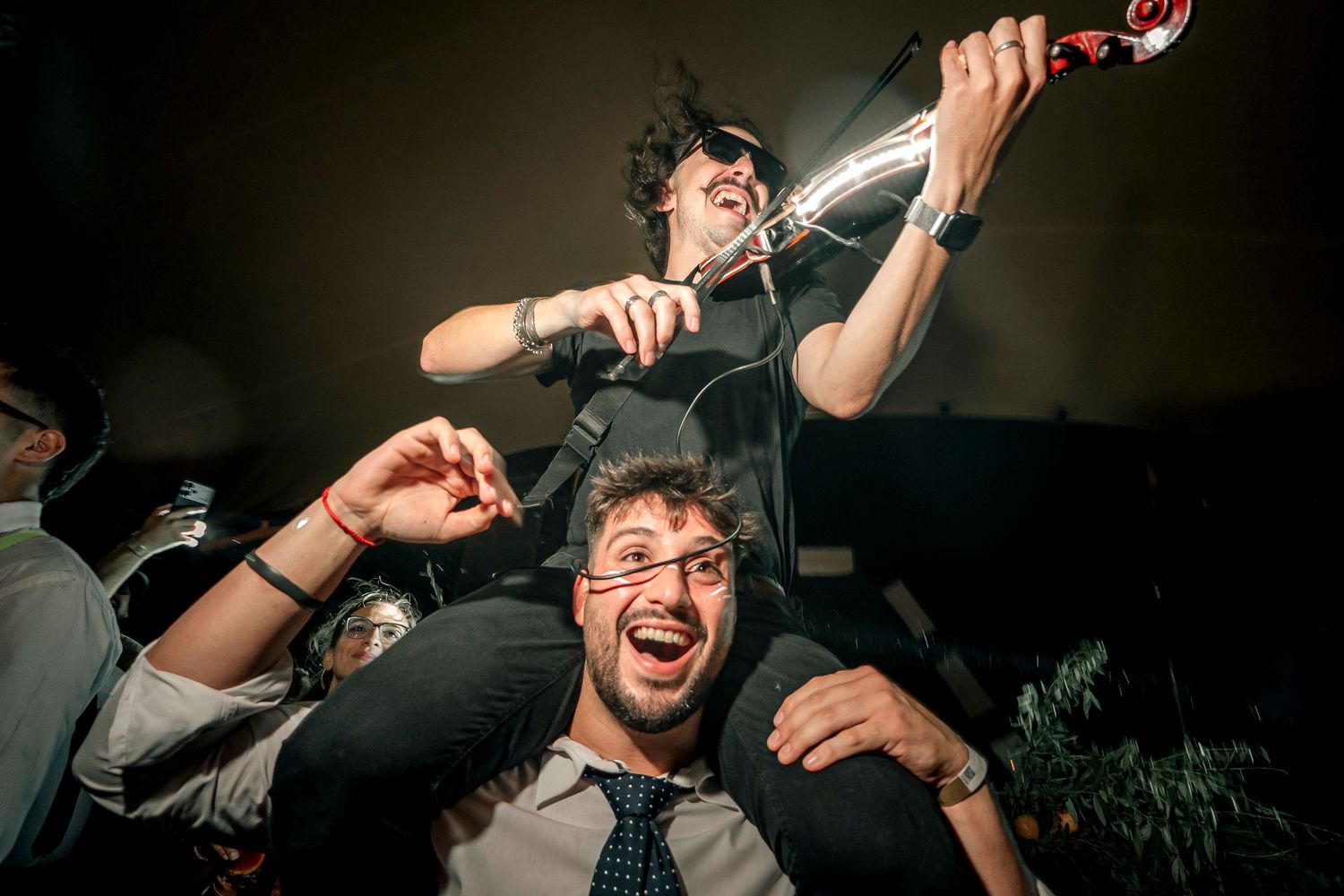 Energetic performer screams into microphone during intense live concert performance in dark venue.