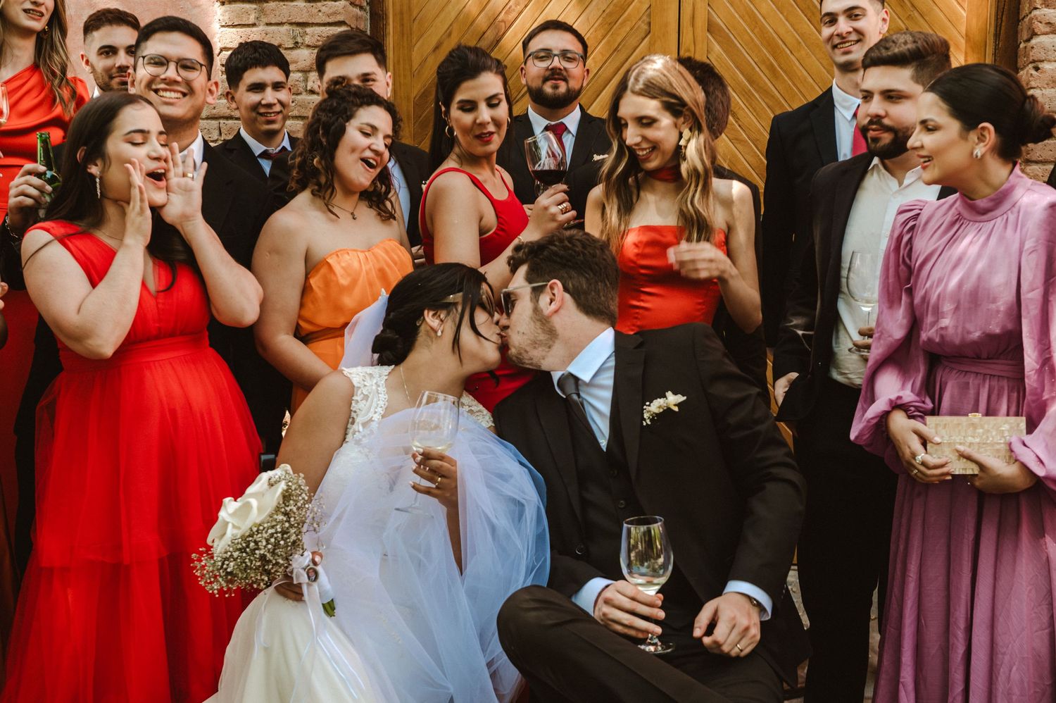 A set of candid photos capturing joyful moments and celebrations at a formal wedding reception with guests in red and purple attire.