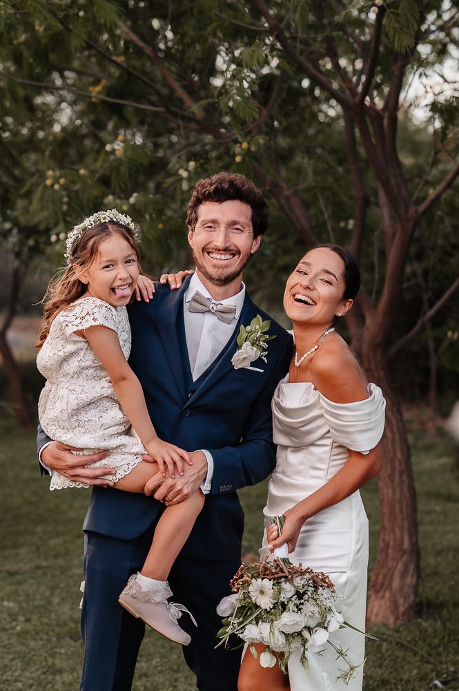A joyful wedding party shares candid laughs together in an outdoor garden setting with natural lighting. wedding in mendoza