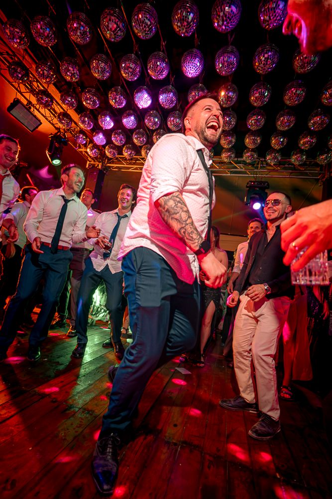 Crowded dance floor with red and purple lighting as people celebrate at a party. wedding in mendoza