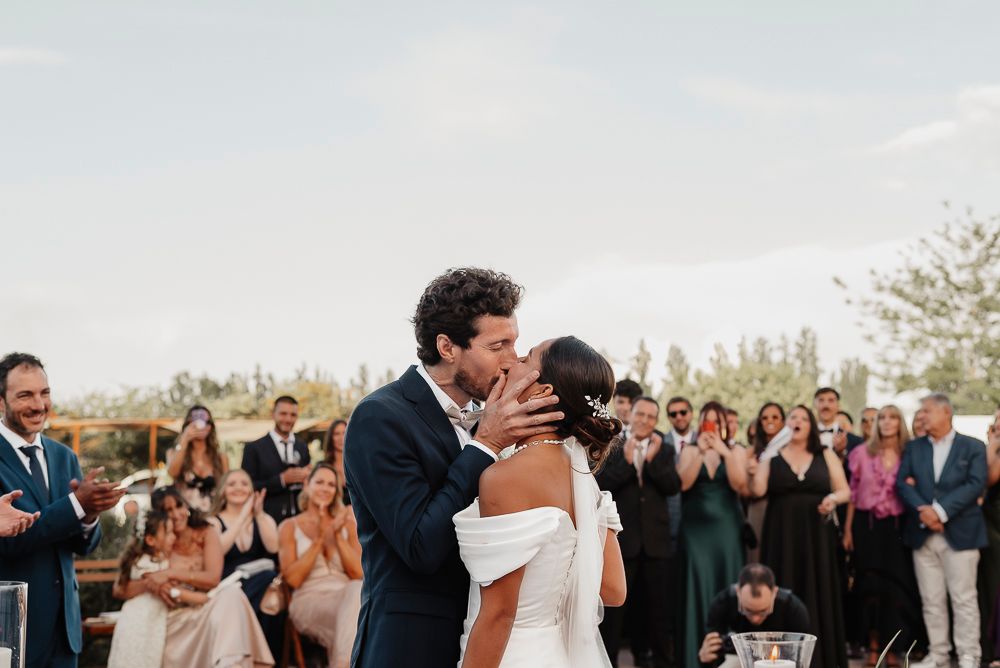 A wedding couple shares their first dance surrounded by guests at an outdoor celebration during golden hour. wedding in mendoza