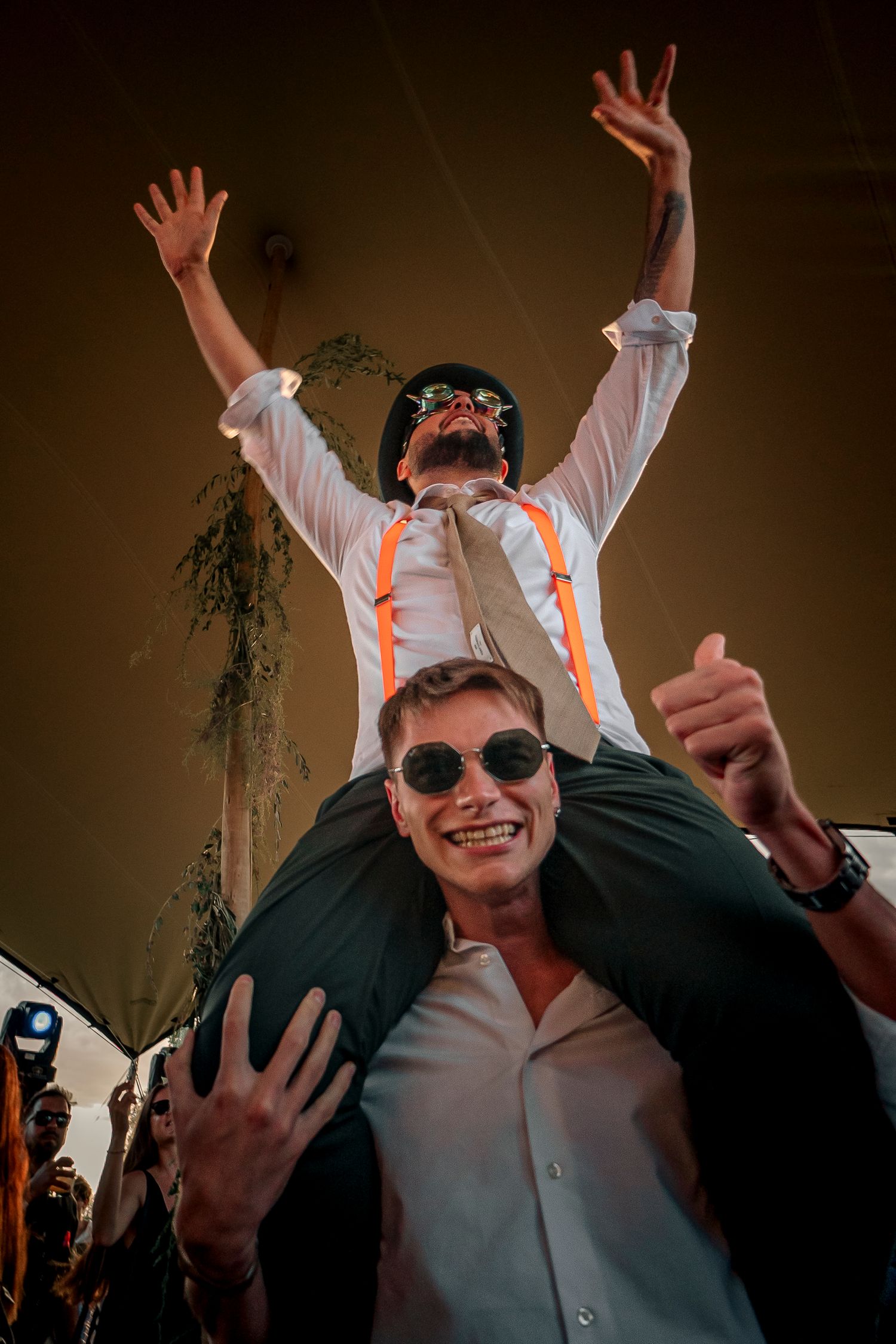 A sequence of celebratory party photos showing someone raising their arms and wearing sunglasses in a dimly lit setting.