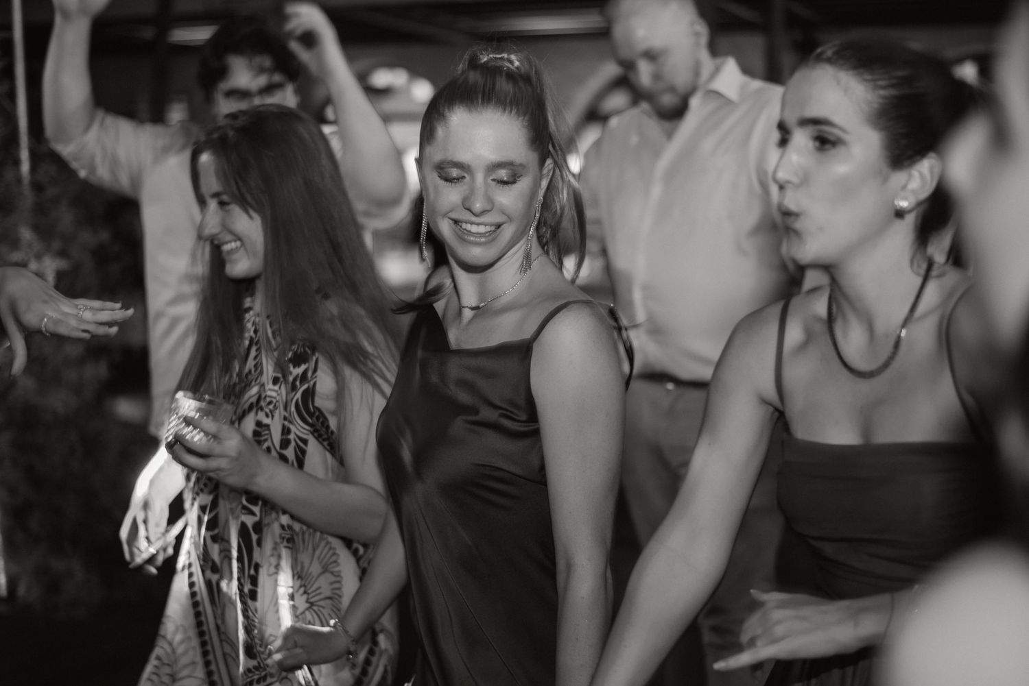 A series of black and white candid party photos showing people laughing and enjoying themselves at a social gathering.
