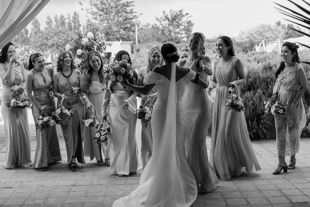Wedding party in coordinated gray and lavender attire poses outdoors for formal group photos at a celebration. wedding in mendoza