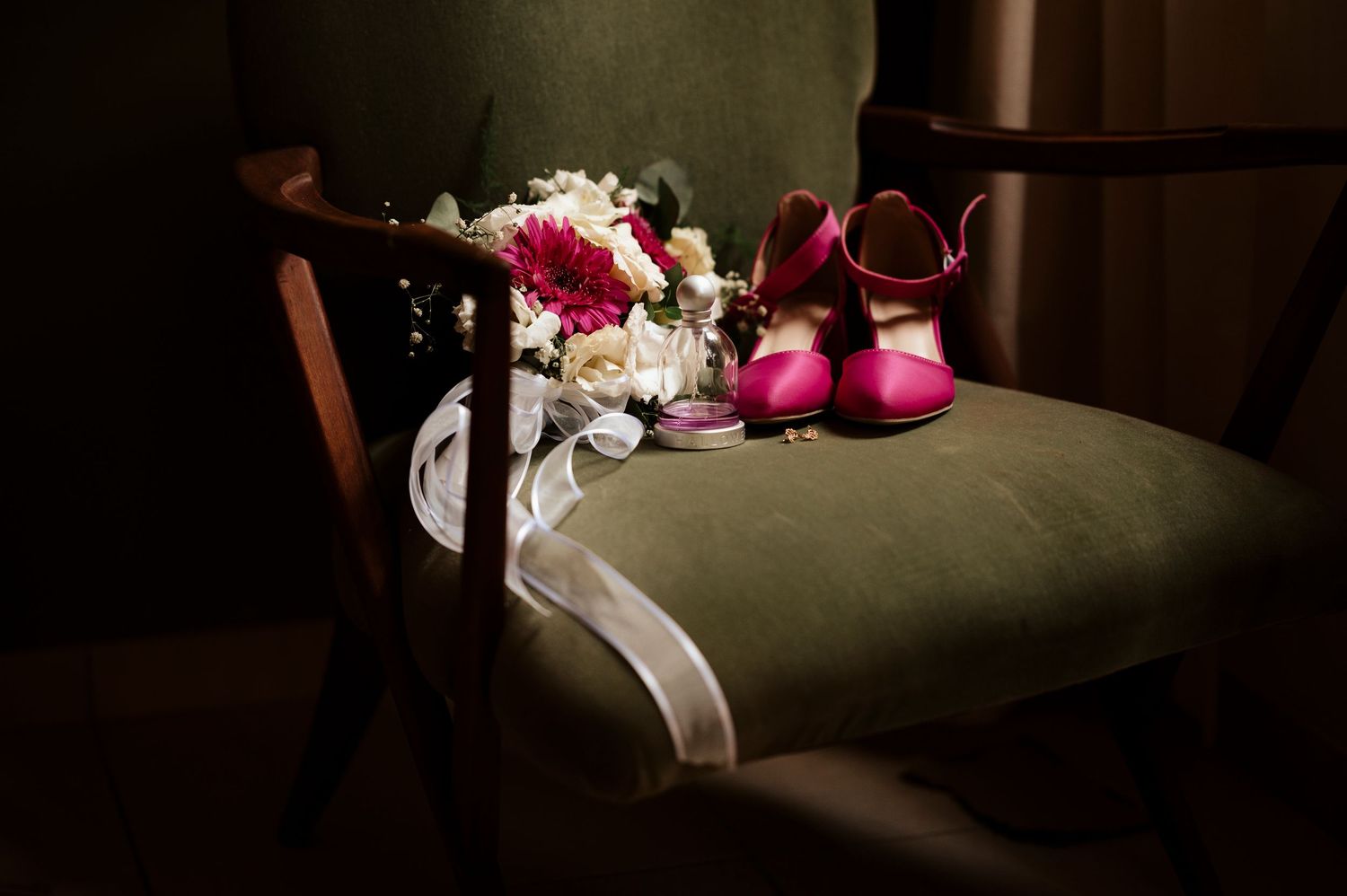 zapatos, ramo, anillos y una silla con una luz suave esperado a que llegue el momento de la boda