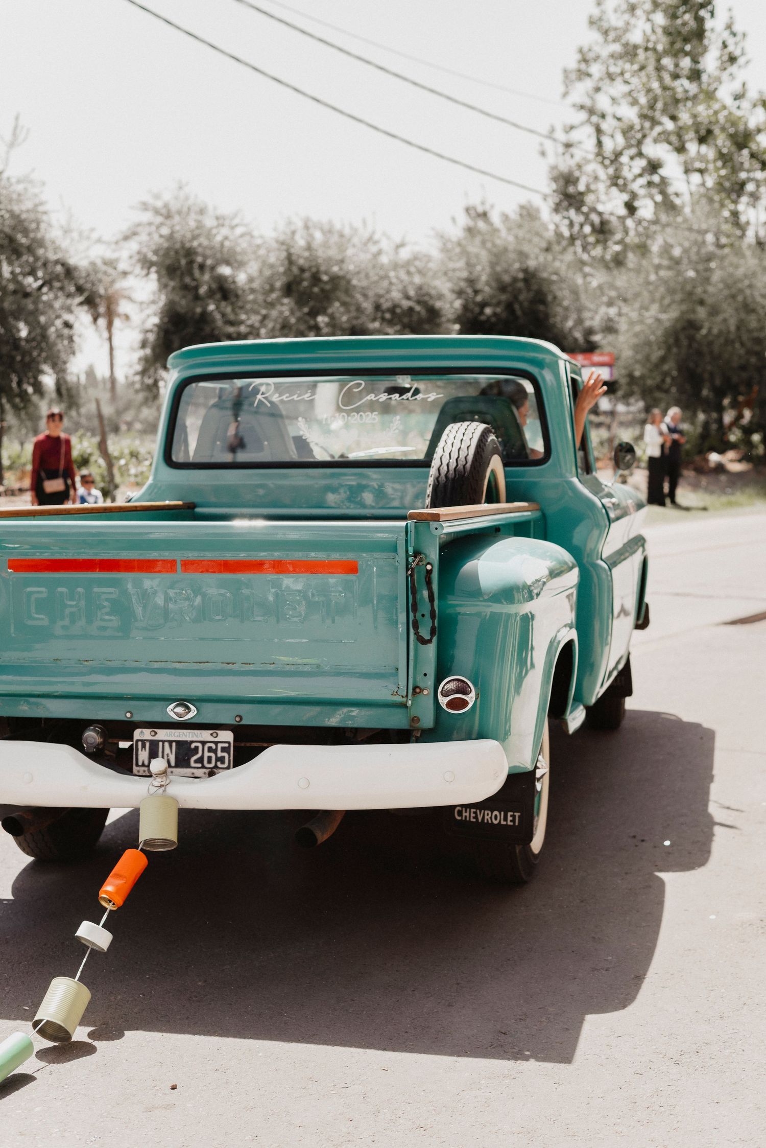 A vintage turquoise Chevrolet pickup truck shown from different rear angles on a paved road.