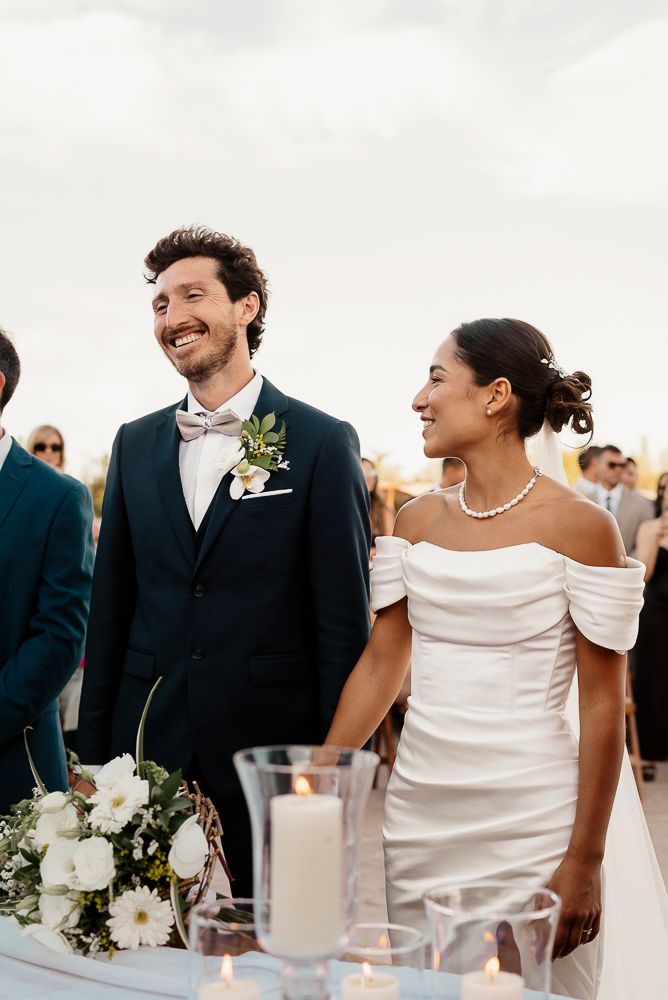A joyful wedding couple shares candid laughter during their reception celebration while seated at a table. wedding in mendoza