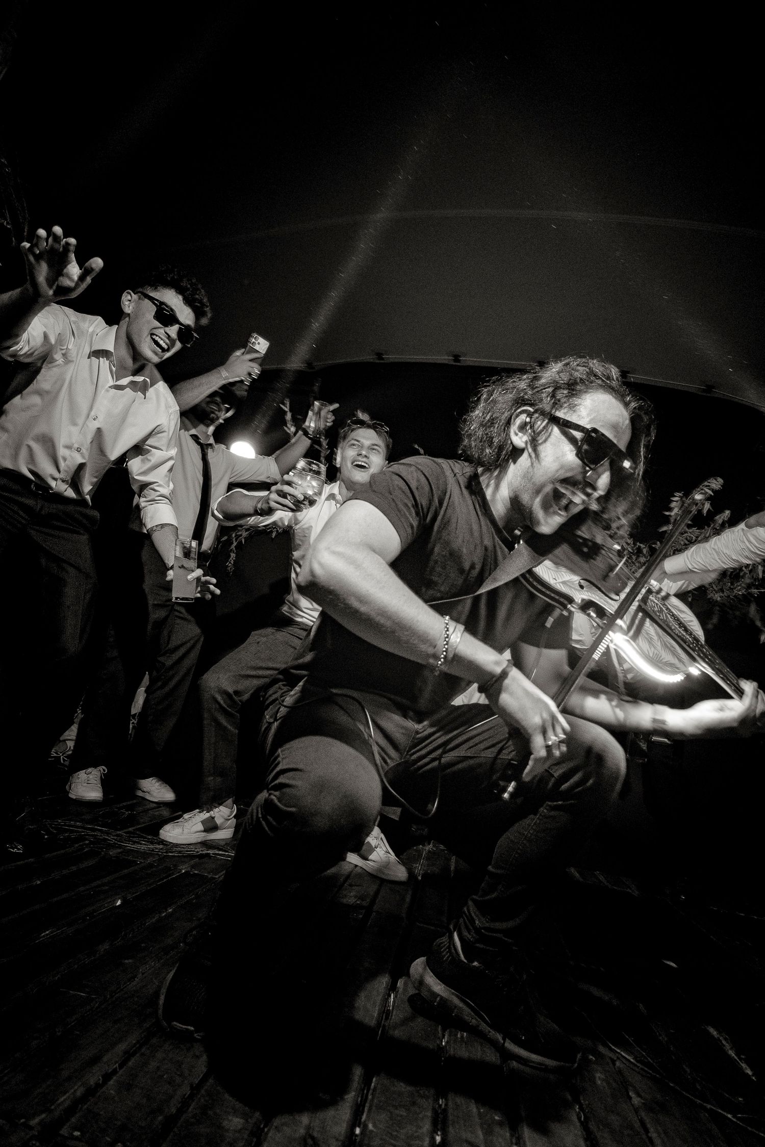 Black and white photos of an energetic punk rock concert performance with musicians and crowd in intense motion.