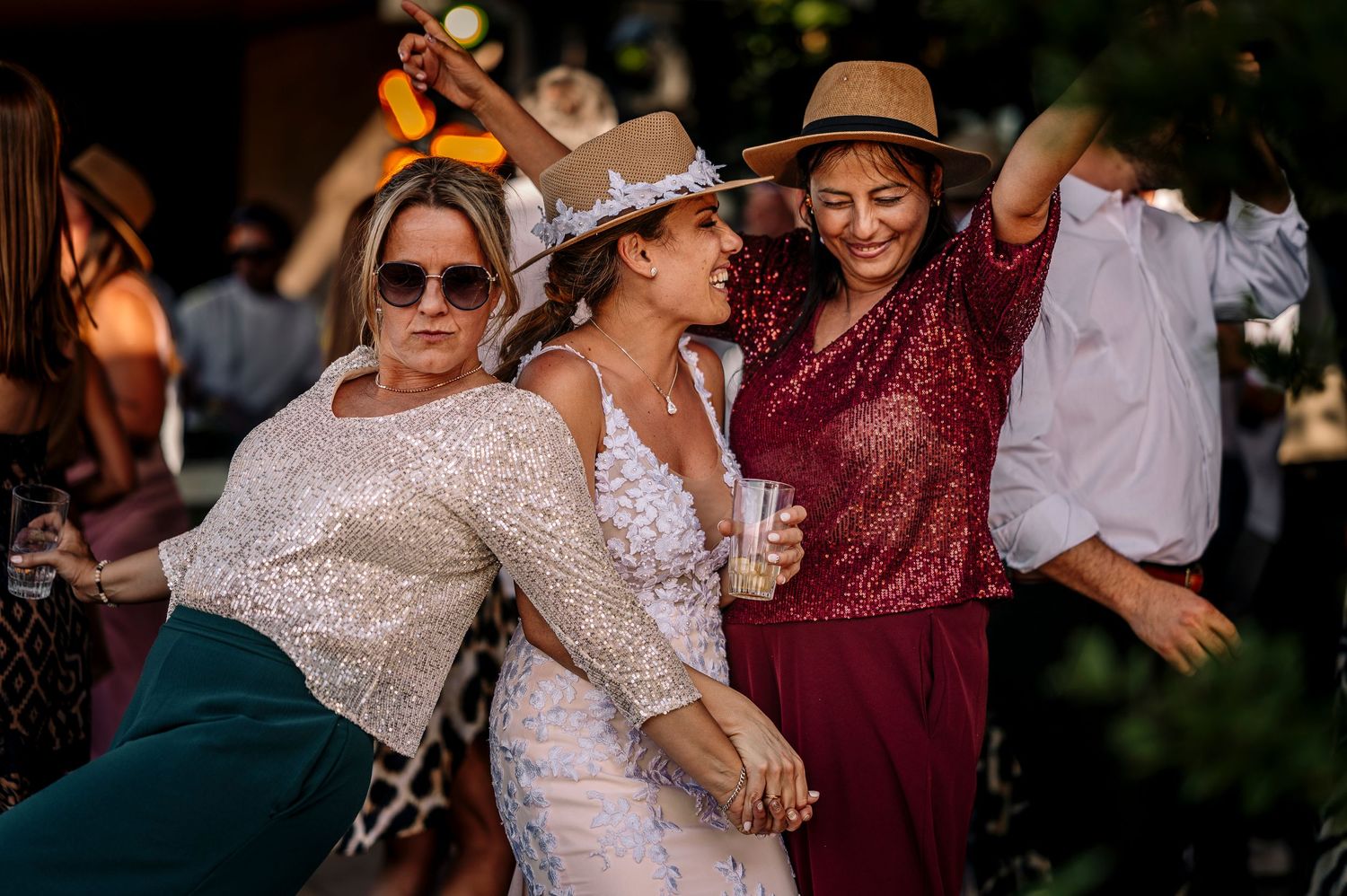 Wedding guests dance and celebrate together at an outdoor reception party in formal attire.