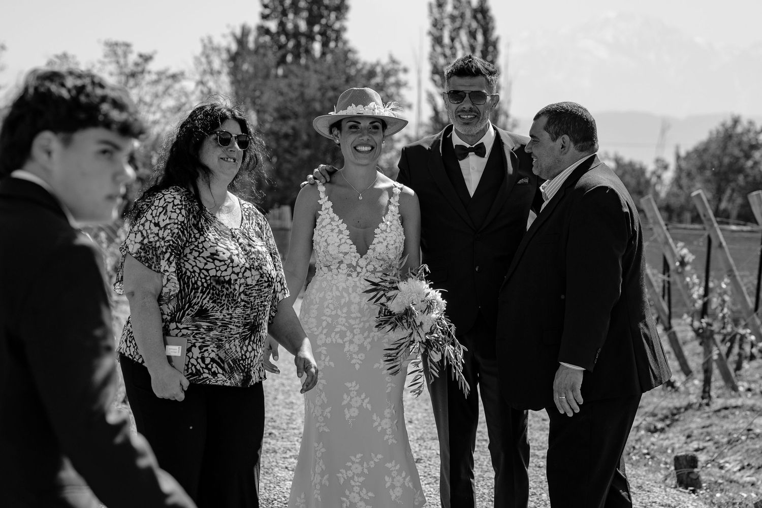 Black and white photos from a wedding celebration show guests and couple enjoying an outdoor garden reception.