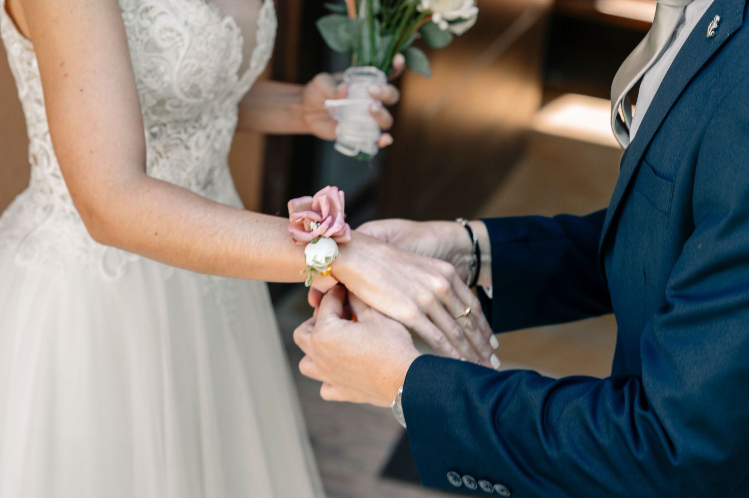 Close-up shot of wedding couple exchanging corsages during ceremony.