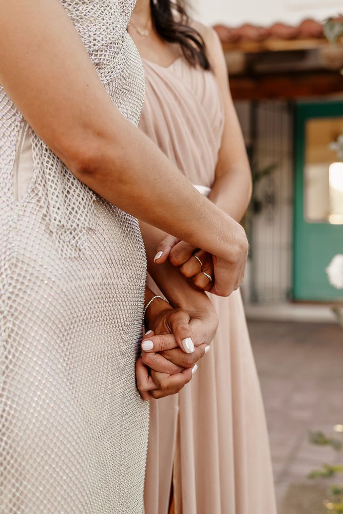 Bridesmaids in blush pink dresses stand in a row holding hands during wedding ceremony.  wedding in mendoza