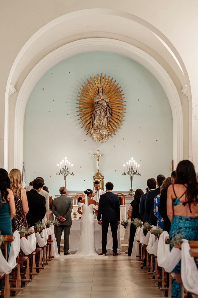 Wedding ceremony in a beautiful white chapel with arched ceilings and a sunburst altar decoration. wedding in mendoza