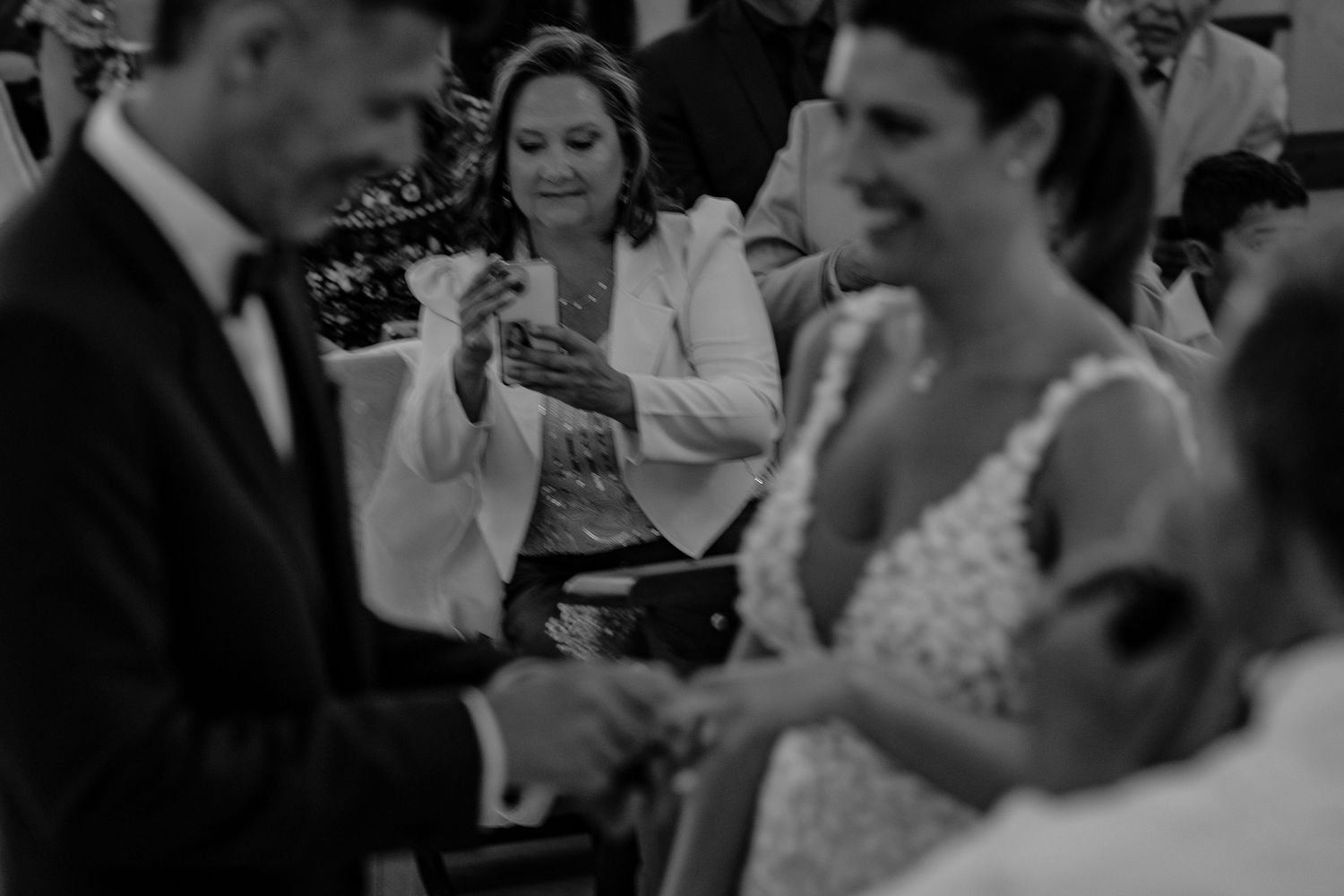 Wedding guests dance and celebrate together on a dimly lit dance floor during an evening reception.