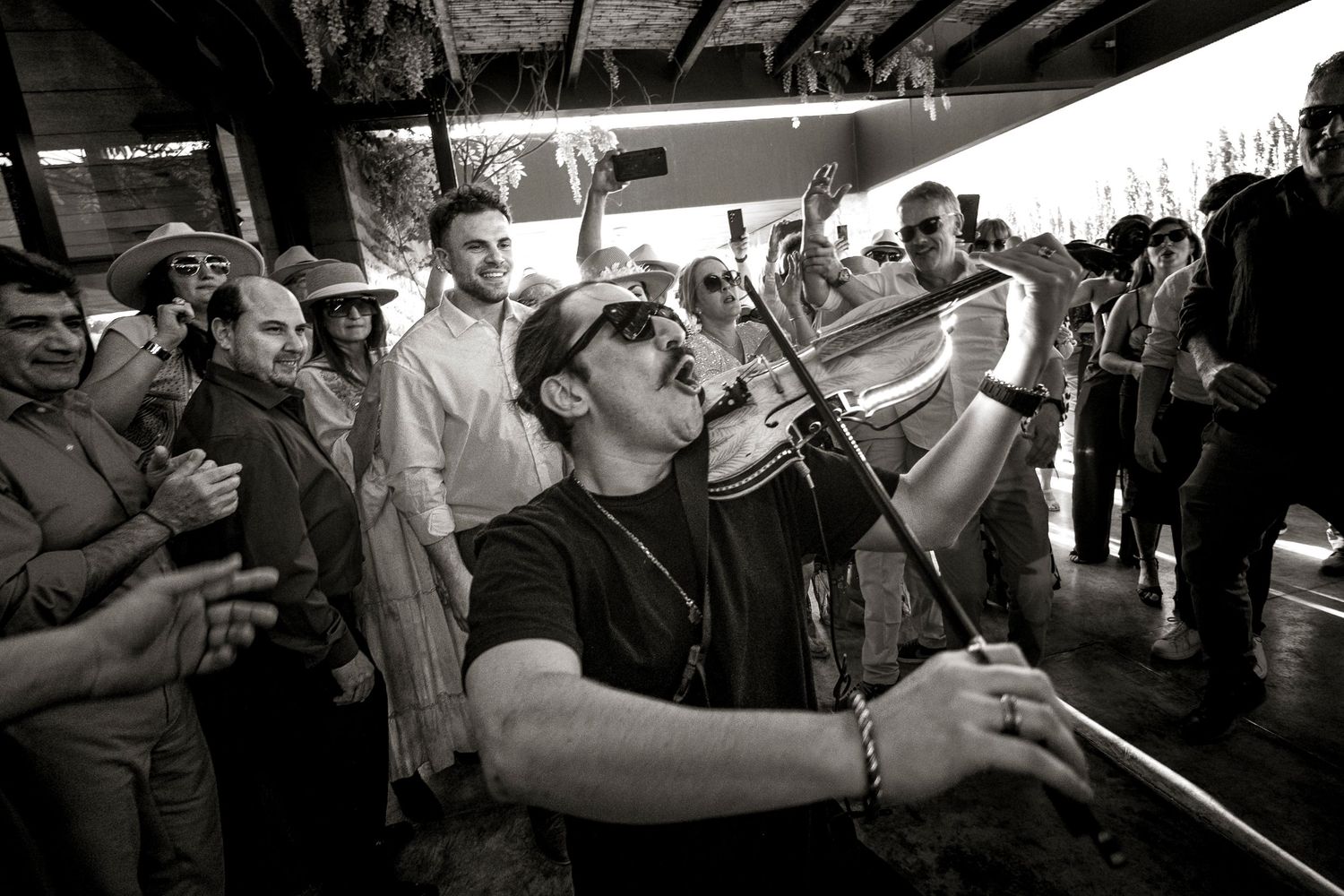 A series of black and white photos showing people drinking from bottles in a crowded social setting.