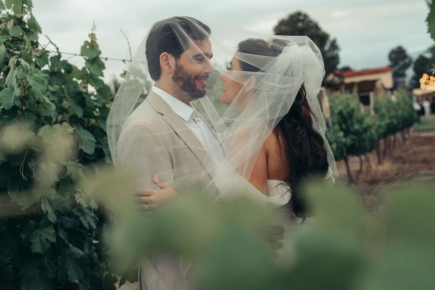 A romantic wedding moment captured between newlyweds embracing in a vineyard with soft natural lighting. fotografos de boda en mendoza