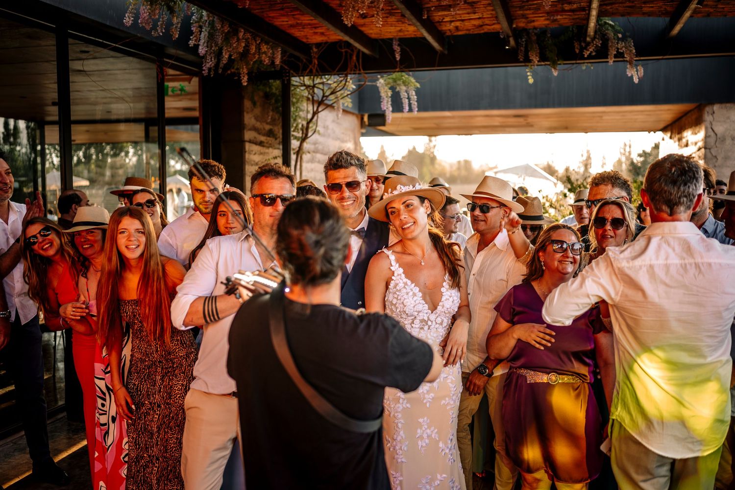Wedding guests dance and celebrate together during a lively reception party at sunset.