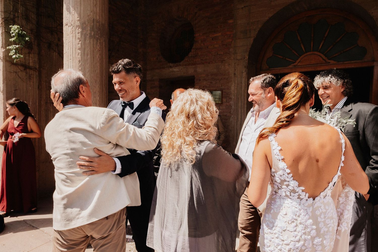 Wedding party members dance and celebrate during a lively reception in a grand ballroom setting.