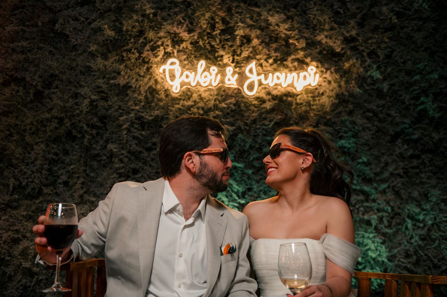 A romantic wedding couple shares an intimate moment under glowing lights at an outdoor evening reception. fotografos de boda en mendoza